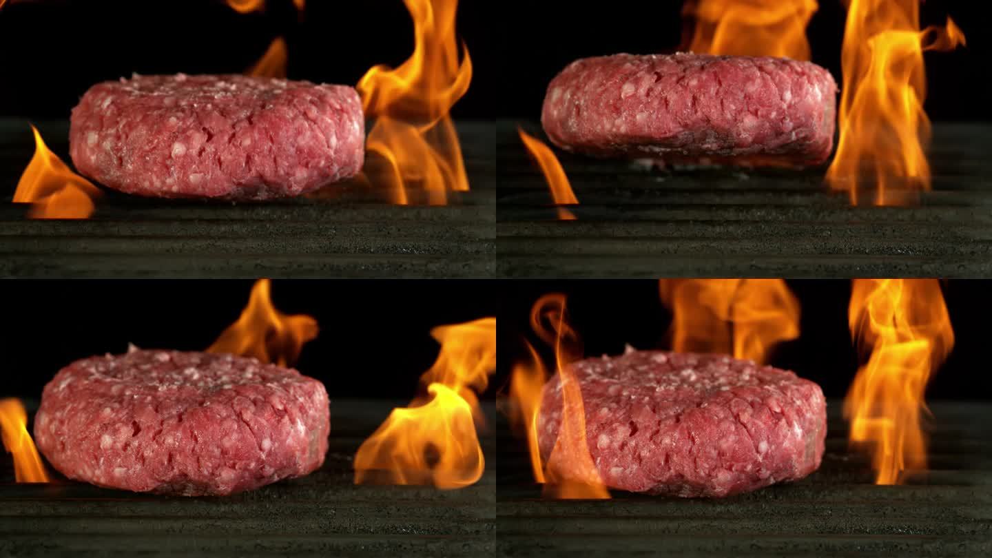超级慢动作的牛肉碎餐在火上烧烤，黑色背景。