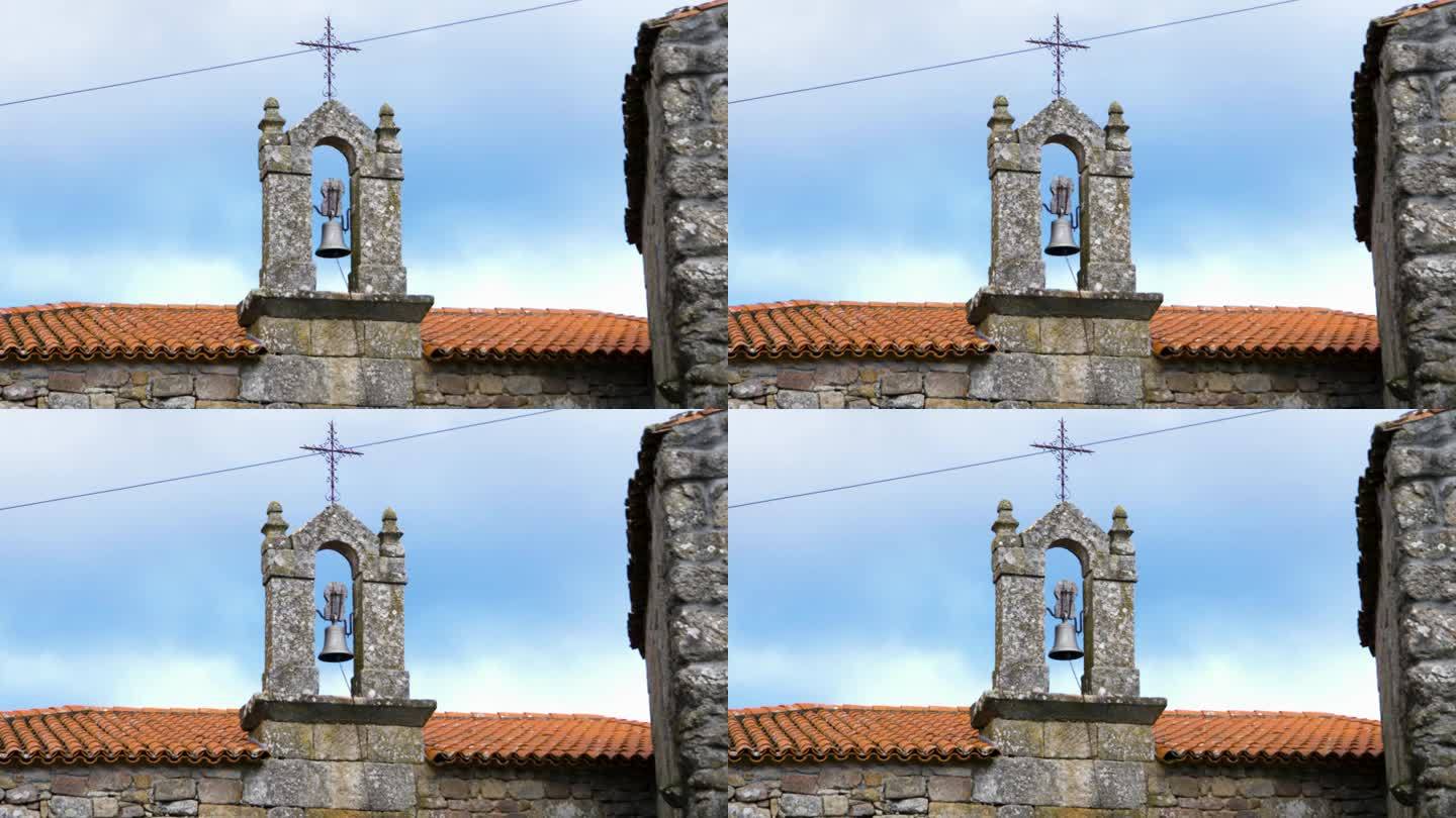 橙色屋顶教堂石柱拱门之间的铁钟的广角视图