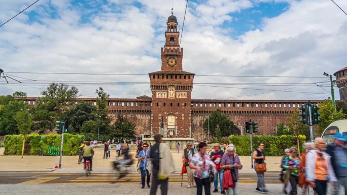 意大利米兰市中心，夏季，菲拉雷特塔和斯福尔扎斯科城堡的城市街道交通路口，游客步行和人行横道与移动的有