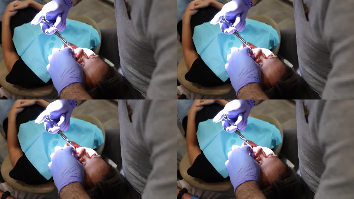 牙医给一名妇女注射止痛药，以拔除病牙