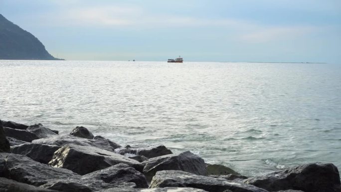 海浪拍打着岩石海岸，溅起水花，在地平线上翻船。平静和宁静，冥想和放松，自然美景的屏幕保护程序。岩石海