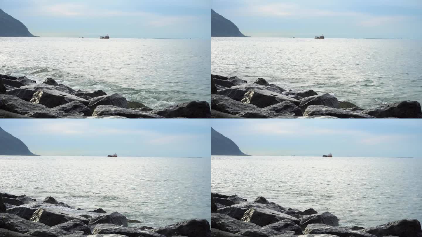 海浪拍打着岩石海岸，溅起水花，在地平线上翻船。平静和宁静，冥想和放松，自然美景的屏幕保护程序。岩石海