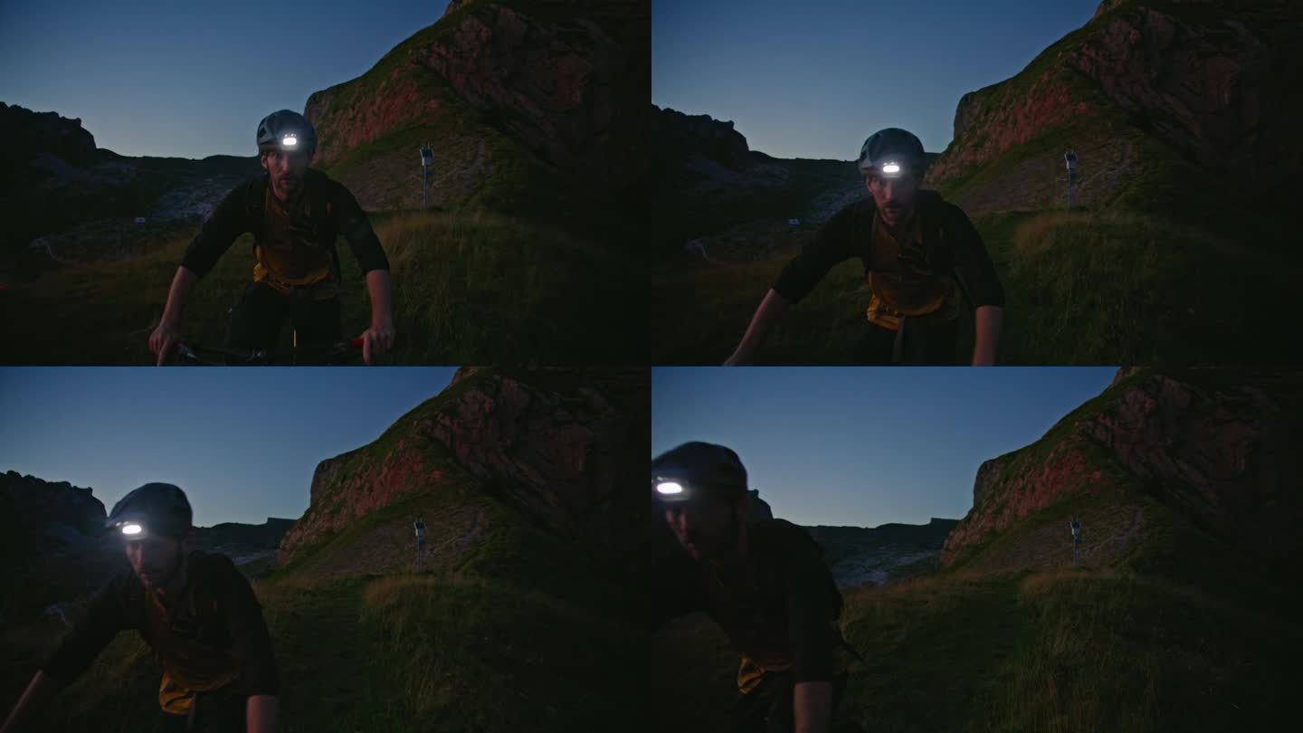 SLO MO决定骑自行车的人戴着发光的头灯在草地上骑自行车，在暮色中湛蓝的天空