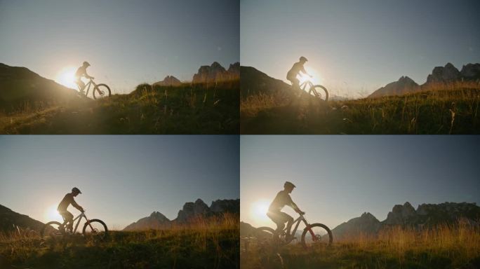 在明亮的夕阳下，坚定的山地自行车手在晴朗的天空下骑自行车的SLO手持镜头
