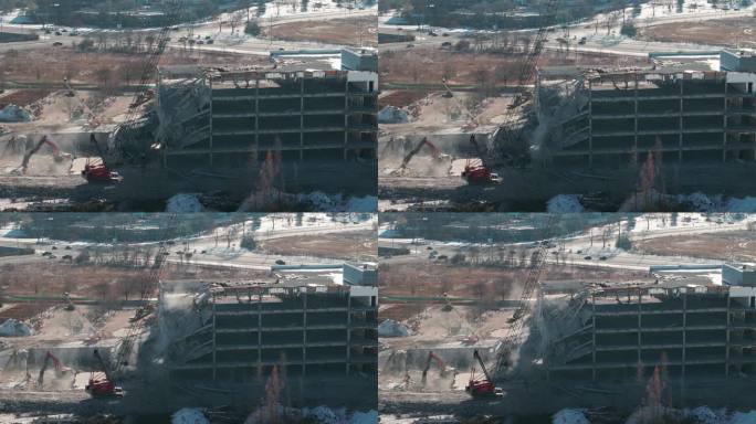 被毁建筑物的广角航拍照片。拆除建筑物。挖掘机在拆迁现场清理垃圾。