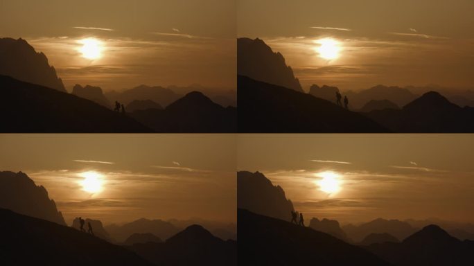 慢动作锁定中距离拍摄的剪影夫妇爬山对戏剧性的天空在日落