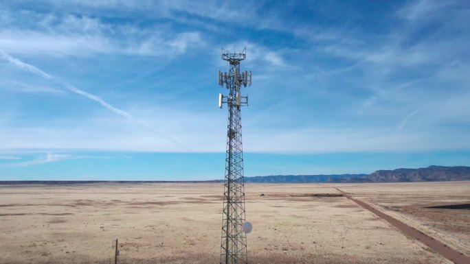 无人机拍摄的犹他州沙漠5G手机塔在一个阳光明媚的冬日，天空充满了云