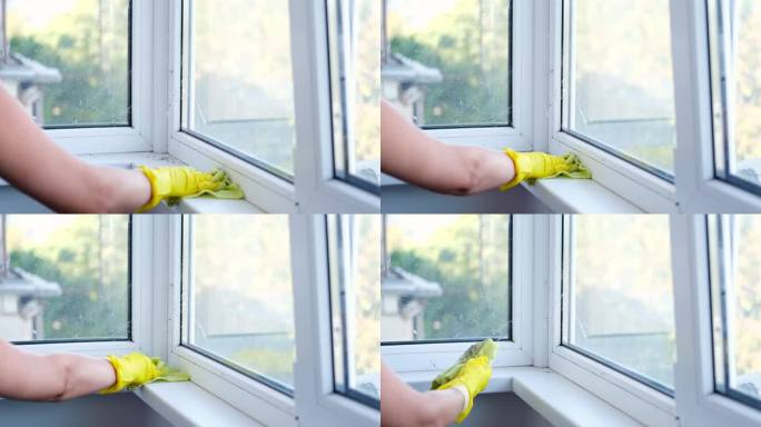 清洁窗台用超细纤维抹布擦拭玻璃窗上的灰尘。概念一般春季大扫除。