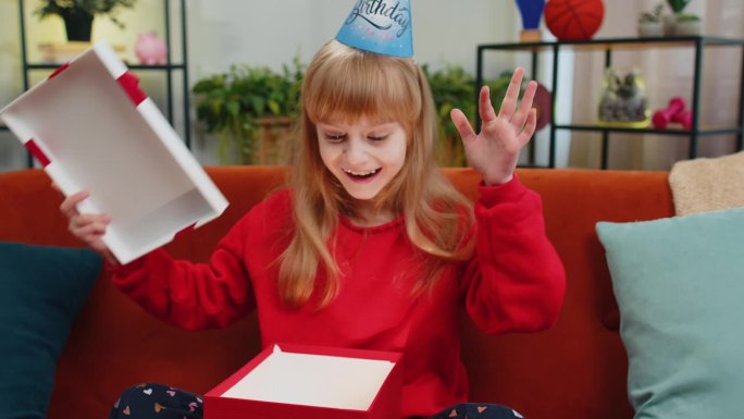 快乐的童女童女拿着带彩带的生日礼盒，在家里开庆祝会，打开礼物