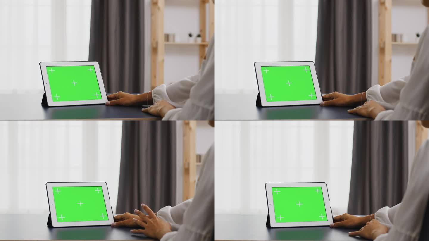 使用绿屏平板电脑的妇女