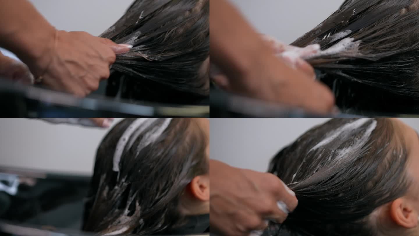 一位女发型师将她的手均匀地涂在躺在椅子上的女孩的湿头发上。特写镜头。