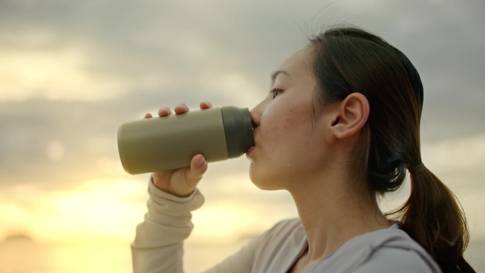 疲惫的运动妇女早上喝水