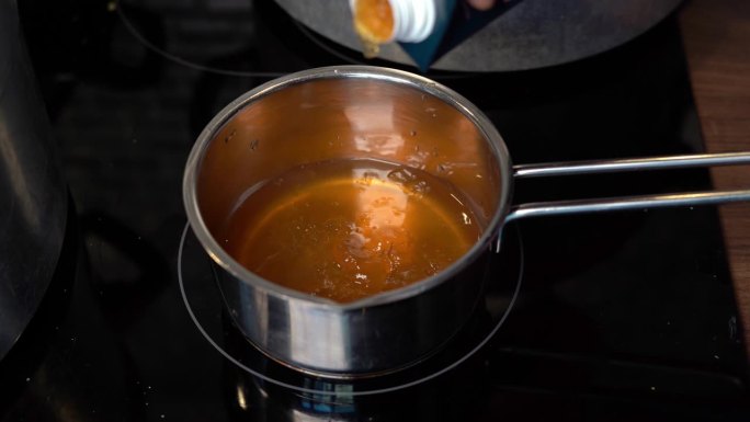 将富含胶原蛋白的骨汤从纸盒倒入锅中加热