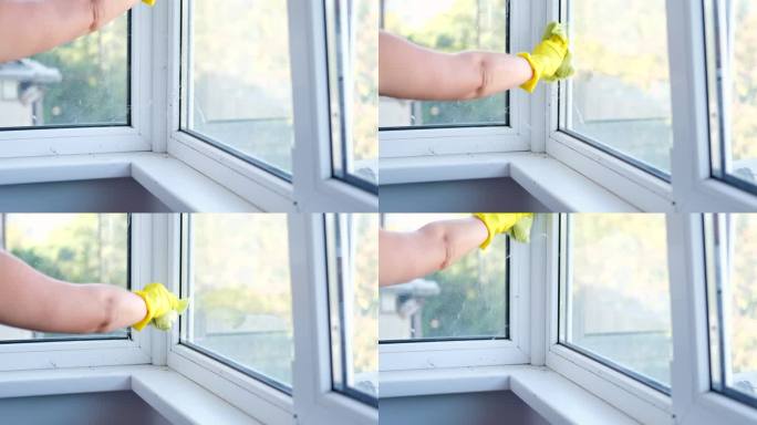 清洁窗台用超细纤维抹布擦拭玻璃窗上的灰尘。概念一般春季大扫除。