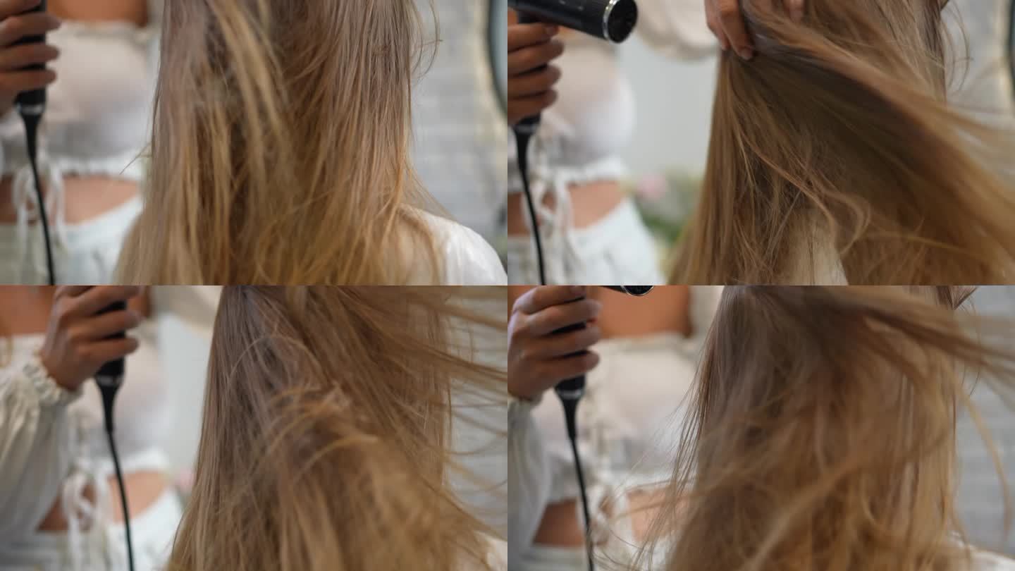 女理发师用吹风机把风吹到女孩的头发上，时不时地用手把头发吹松。特写镜头。