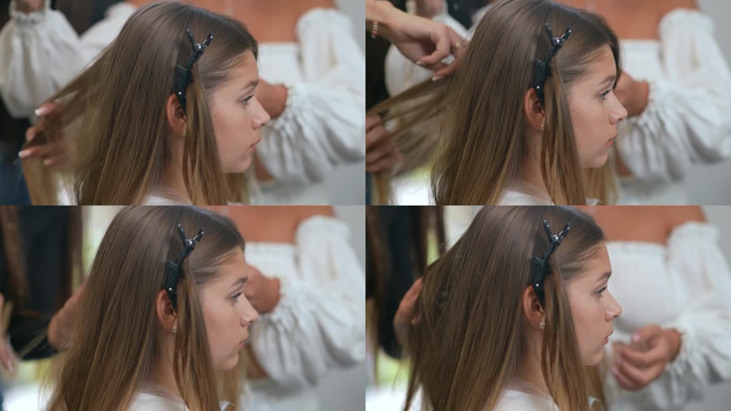 特写镜头。沙龙里一个长发女孩的侧面特写，背景是两个理发师在给她做头发。
