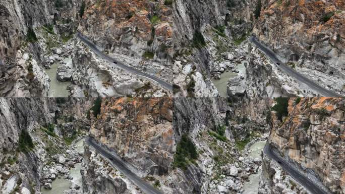 一辆汽车在山边的危险道路上行驶的航拍视频，旁边是一条河流，穿过岩石山谷，河里有大量的巨石和石头掉落。