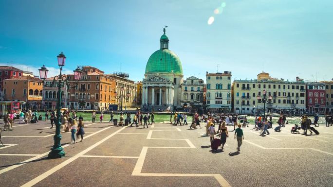 意大利威尼斯，游客和行人在中央车站前走过，穿过大运河和圣西蒙尼教堂