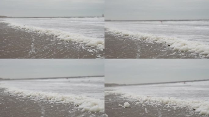 北海的冬天。背景是冲浪者。前景是海沫。
