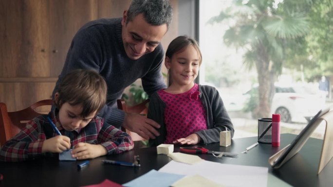 孩子和父亲做折纸玩具使用彩色纸按照步骤在视频教程中指示的数字平板电脑