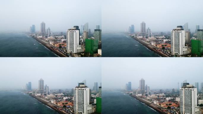 科伦坡鸟瞰图，沿海的高楼大厦，城市景观。雾蒙蒙的天气遮住了远处的建筑物，海浪拍打着海岸，下面的城市生