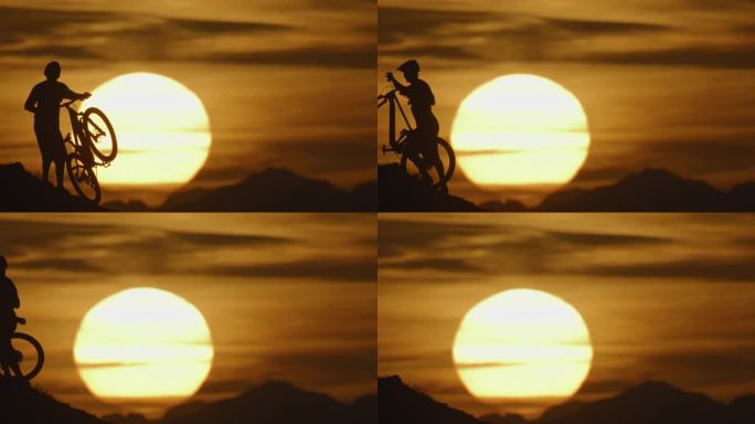 SLO MO锁定的剪影山地自行车手扛着自行车上山在日落田园诗般的太阳