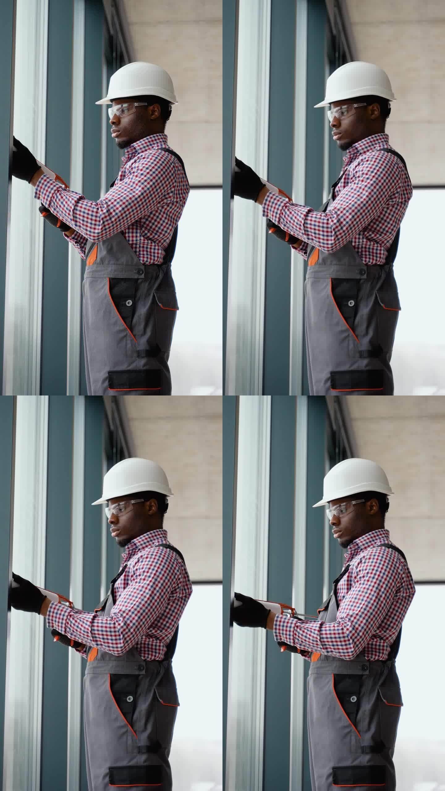 非洲窗户安装工人在安装pvc窗户时使用硅胶泡沫。垂直视频