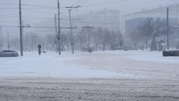 暴风雪中城市街道上车辆和行人的交通状况