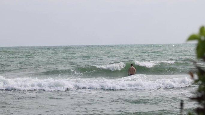 勇敢面对波涛汹涌的海浪的游泳者