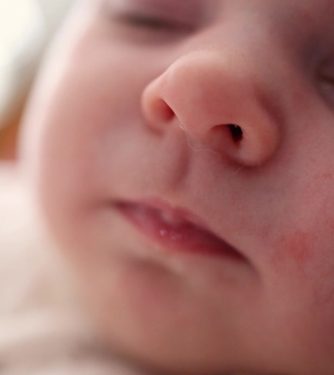 一个小孩睡着的脸部特写。嘴唇，鼻子，眼睛。宏。垂直视频。宝宝头半脸