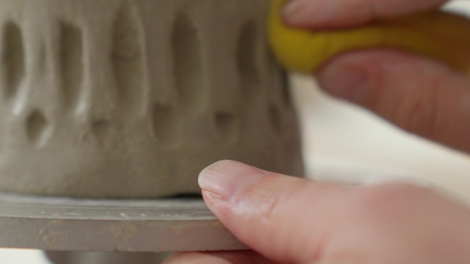 在柔软的粘土上使用海绵，工匠将杯子的两侧无缝地融合在一起，展示了精致的触感和工艺