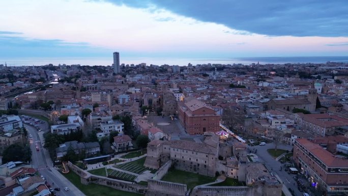 日落时分，意大利艾米利亚-罗马涅地区的西斯蒙多城堡与里米尼城市景观