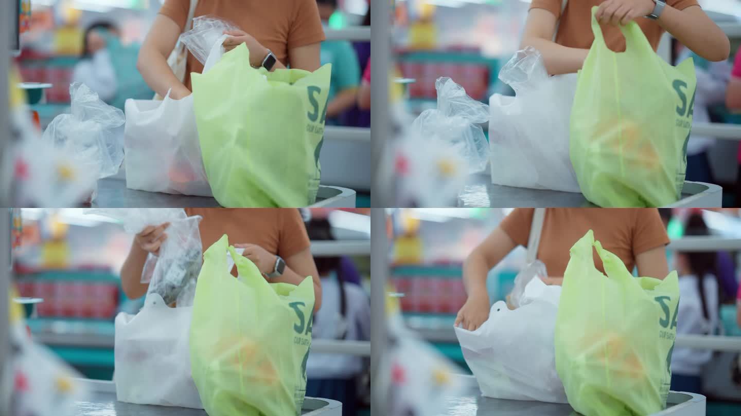 女顾客在超市使用自助收银台。