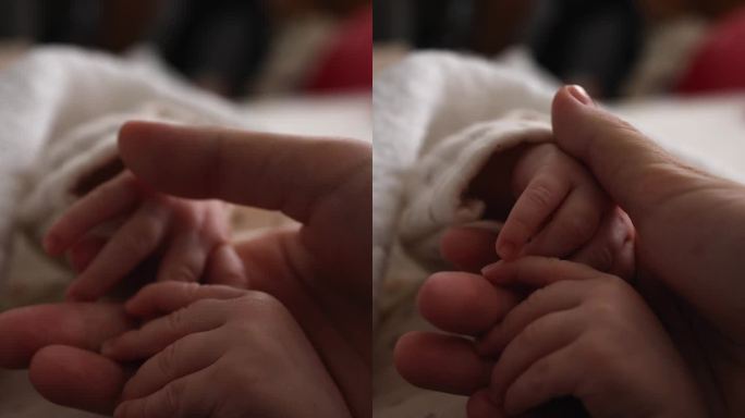 妈妈的手和宝宝。母亲握着孩子的手。手拉手垂直视频。特写镜头