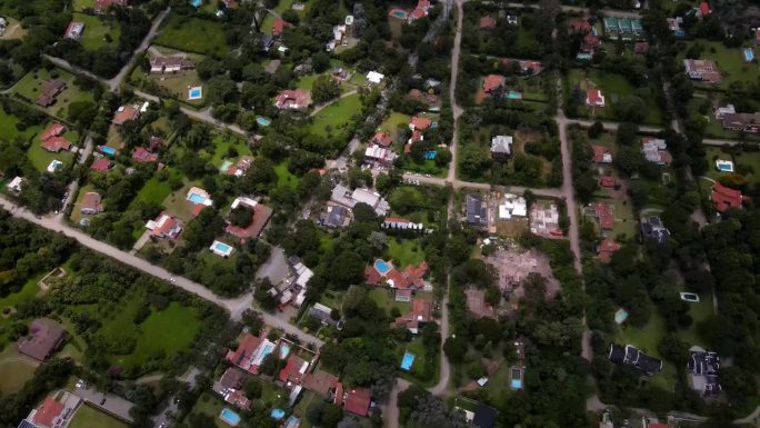 一架无人机在阿根廷萨尔塔市的郊区上空拍摄，同时将画面向上平移，显示远处的城市。