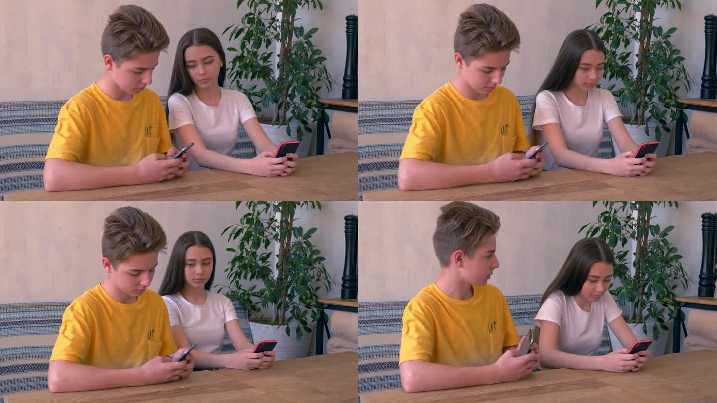年轻的朋友们坐在一起，女孩试图偷看男孩的手机屏幕