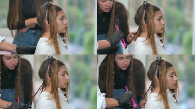 一位女发型师老师看着一位戴着黑色橡胶手套的新手发型师用梳子从客户头上梳下一缕头发。