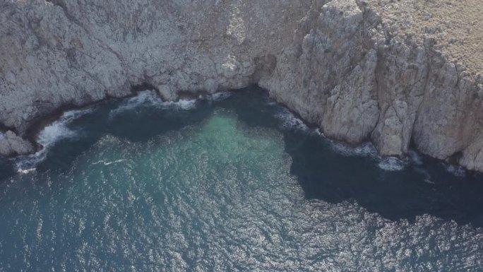 航拍画面显示，地中海海浪冲击着希腊克里特岛的岩石悬崖