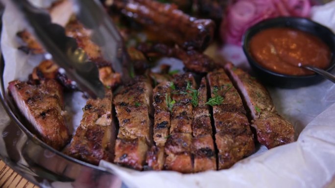 拿一块美味的烤肉放在肉盘里，配上羊肉、猪肉、牛肉和鸡肉酱。在餐厅服务
