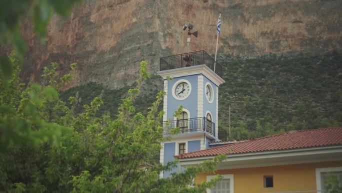 在希腊列奥尼迪奥的悬崖下，挂着希腊国旗的蓝色钟楼充满活力