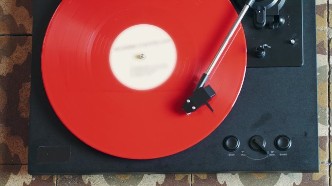 复古黑胶红色唱机播放音乐，近距离微距拍摄复古LP唱片旧留声机旋转。家里的复古音乐播放器。