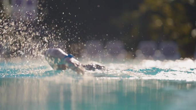 热情的男子游泳运动员在阳光度假泳池完善自由泳