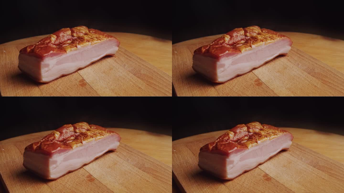 切菜板上的一块煮过的熏牛腩肉。摄像机绕圈移动