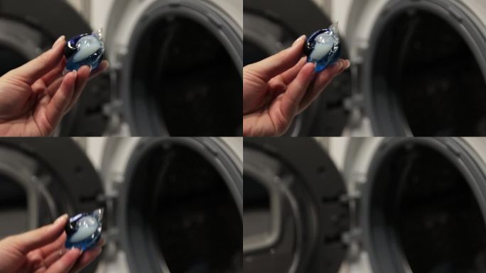 近距离的女人把五颜六色的凝胶胶囊与洗衣粉放在洗衣机脏衣服上。现代液体洗涤剂。