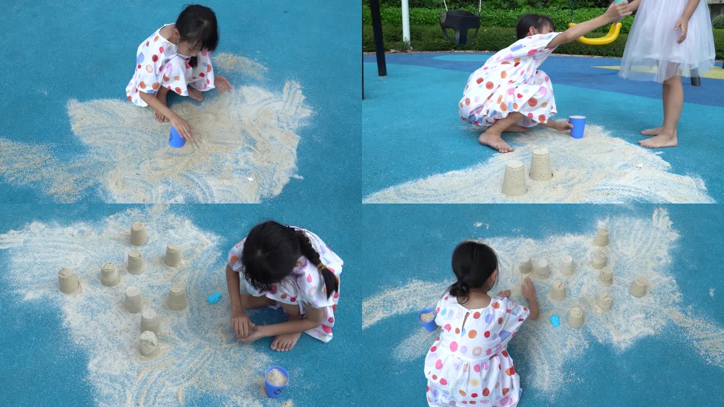 在游乐场蓝色地面上玩沙子的小女孩