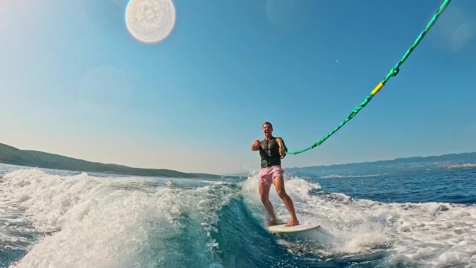 SLO MO男性冲浪者享受滑水板，掌握海浪与快乐的动作在海上