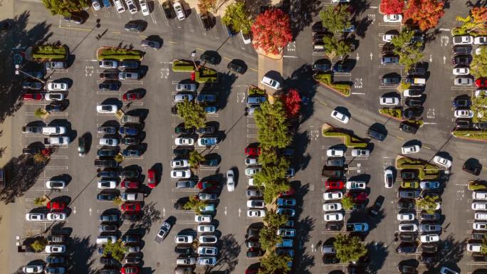 无人机直接在美国的一个停车场上空拍摄，许多汽车停在那里