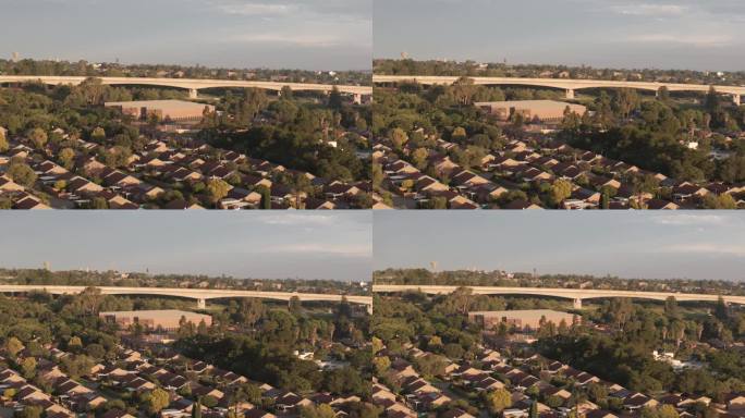 南非百夫长高速列车桥梁和房屋的缓慢旋转无人机镜头