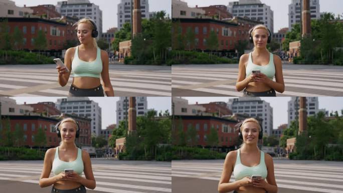 这位年轻的健身运动女性在城市道路上戴着耳机听音乐，微笑着对着镜头摆姿势