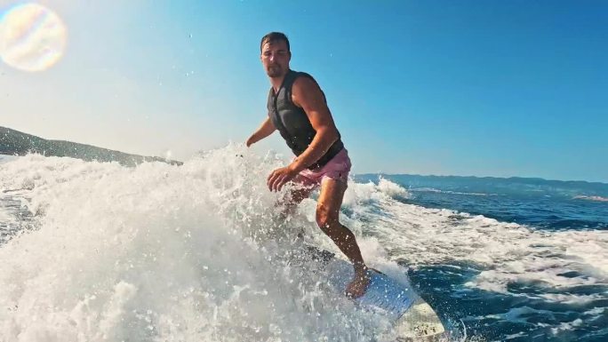 SLO MO男子享受滑水板，在阳光明媚的日子里冲浪